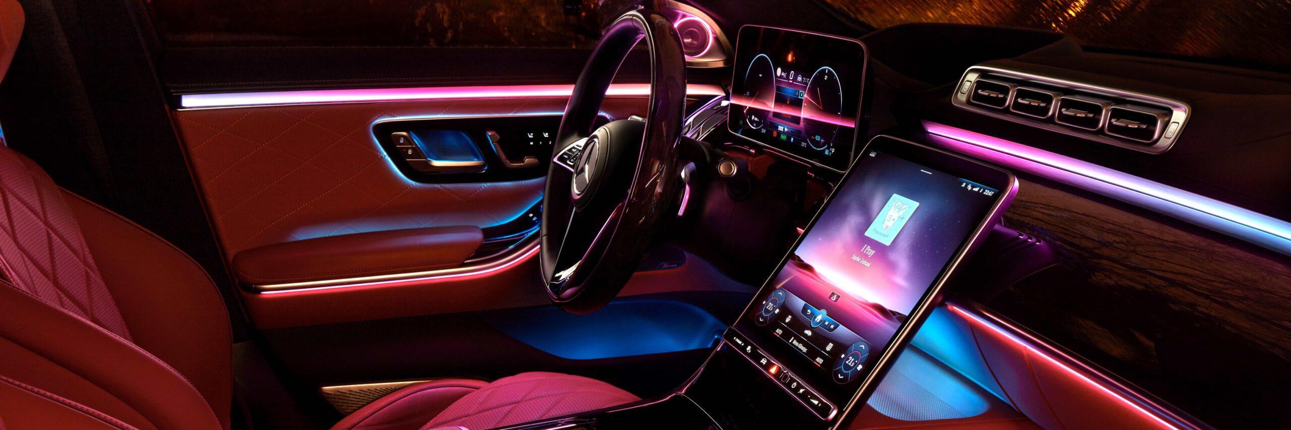 Nachtbeleuchtung im Innenraum der luxuriösen Mercedes S-Klasse mit Echtholz- und Lederausstattung und einem riesigen Multimedia-Bildschirm MBUX. Regnerische Nacht. Symbol „Von der Community überprüft“