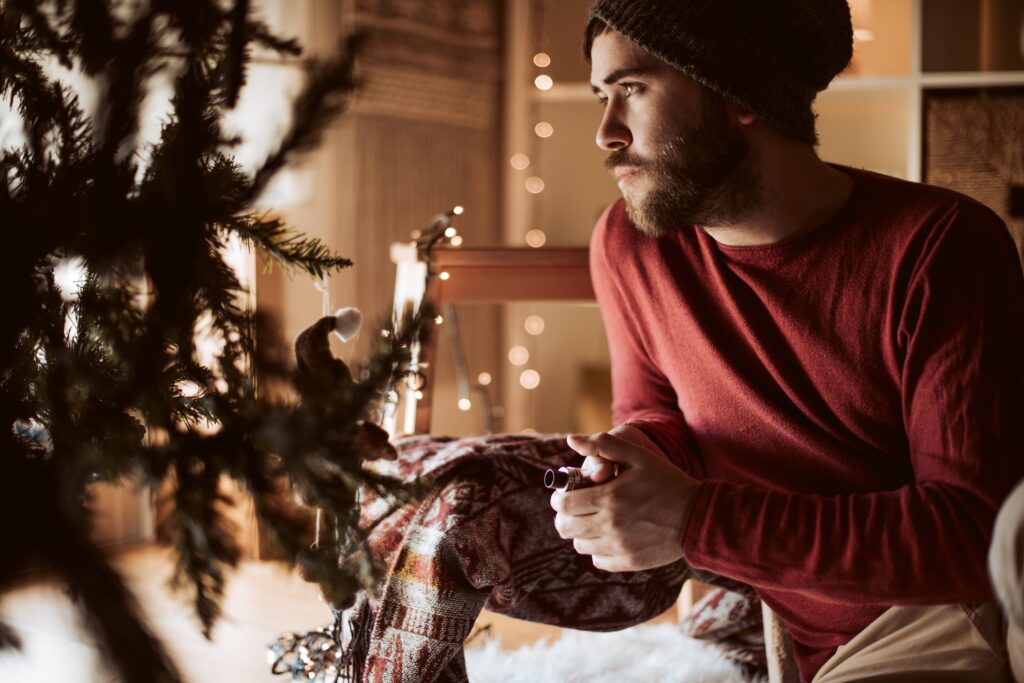 Mann mit Geschenk aus dem Vaporizer Shop im unter dem Weihnachtsbaum