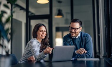 Raumsysteme im modernen Büro: Zwei Mitarbeitende planen Strukturlösungen an einem Laptop
