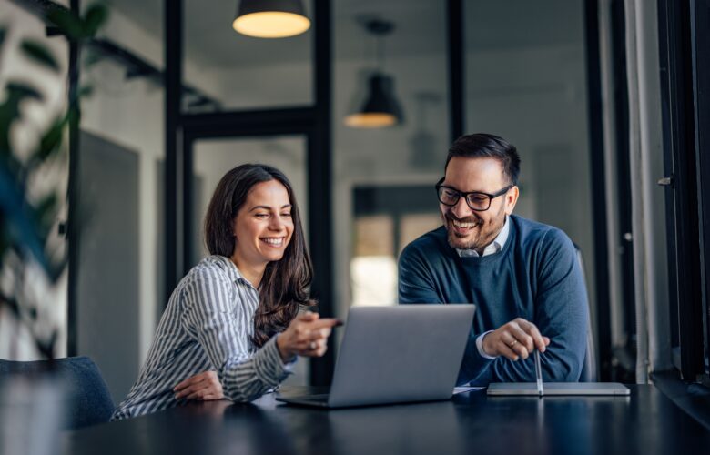 Raumsysteme im modernen Büro: Zwei Mitarbeitende planen Strukturlösungen an einem Laptop