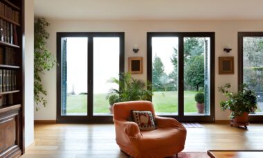 Wohnzimmer mit bodentiefen Fenstern und Blick in den Garten, lichtdurchflutetes Design inspiriert von Fensterbauer Wuppertal