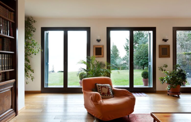 Wohnzimmer mit bodentiefen Fenstern und Blick in den Garten, lichtdurchflutetes Design inspiriert von Fensterbauer Wuppertal