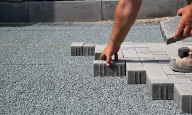 Hand verlegt graue Pflastersteine auf Kiesbett | Parkplatzmarkierung